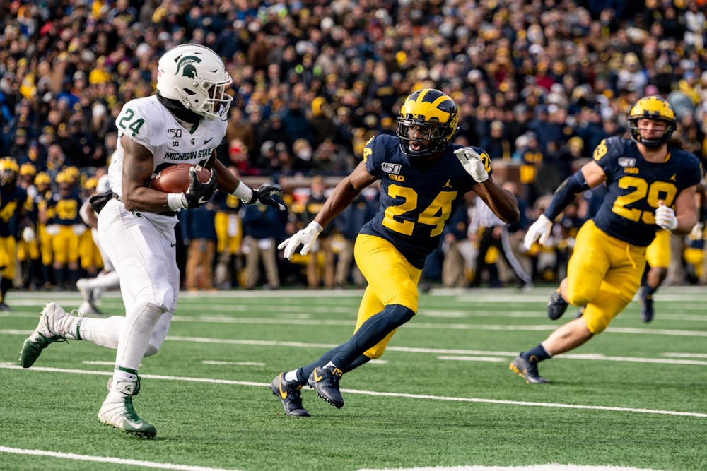 <p>Freshman running back Elijah Collins (left) runs the ball against Michigan. The Spartans fell to the Wolverines, 44-10, at Michigan Stadium on Nov. 16, 2019. </p>