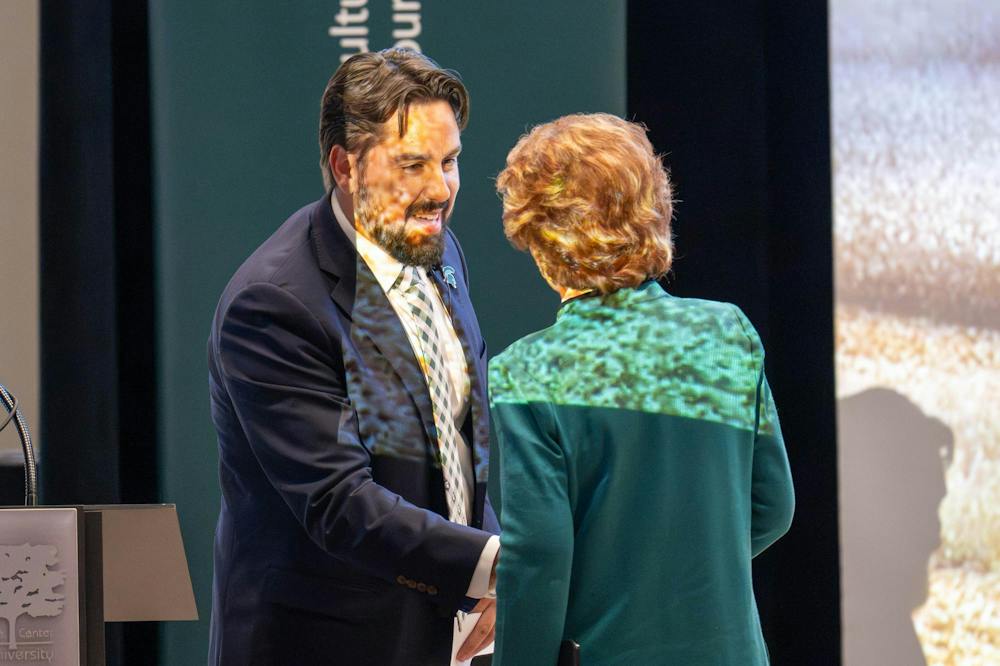 <p>Former U.S. Sen. Debbie Stabenow shakes hands with David Ortega, professor and Noel W. Stuckman Chair in Food Economics and Policy in Michigan State University’s Department of Agricultural, Food and Resource Economics, after Ortega introduces her during the Stuckman Lecture Series at the Kellogg Center in East Lansing, Mich., on Wednesday, Sept. 23, 2026.</p>