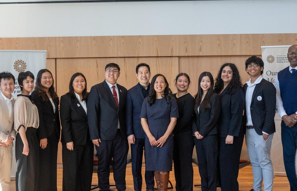 Tina Wei Smith, Co-Vice Chair, and Dennis Chang, Commissioner with the National Asian Pacific American Museum Commission, pose for a group photo with attendees at the Multicultural Center on April 11, 2026.