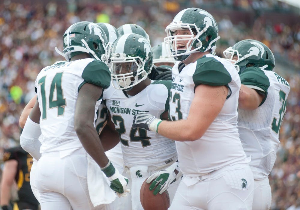 Teammates celebrate with junior running back Le'Veon Bell, who scored a touchdown for MSU. The Spartans defeated the Chippewas, 41-7, on Saturday, Sept. 8, 2012, at Kelly/Shorts Stadium in Mount Pleasant, Mich. Justin Wan/The State News