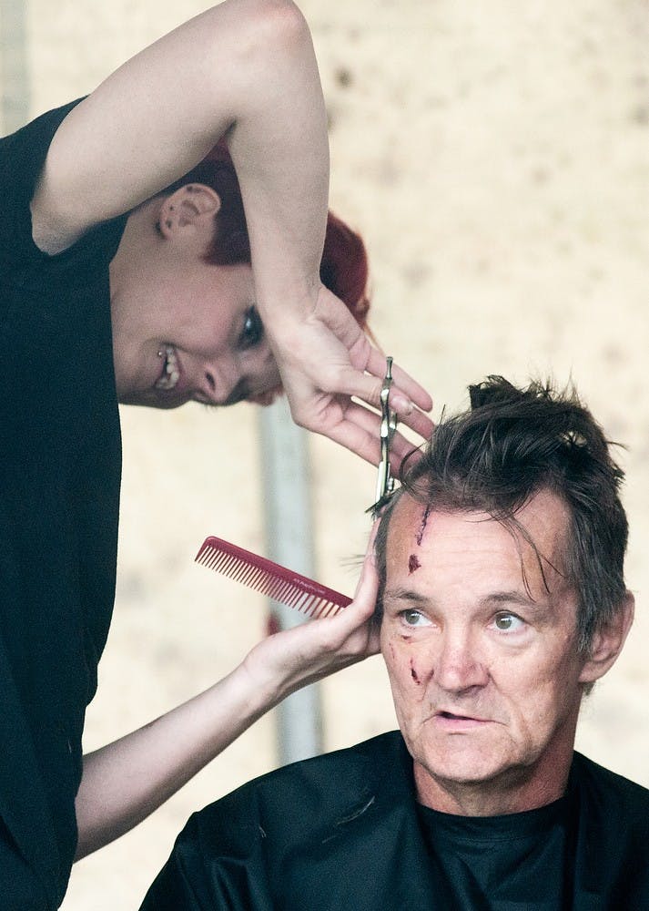 	<p>Lansing resident Carl Berggren gets his hair cut by Douglas J Aveda student Allie Hyatt at the 10th annual Capital Area Stand Down for Homeless Veterans on May 22, 2013, at Adado Riverfront Park in Lansing. The event, hosted by Volunteers of America Michigan, aims to end veteran homelessness. Danyelle Morrow/The State News</p>