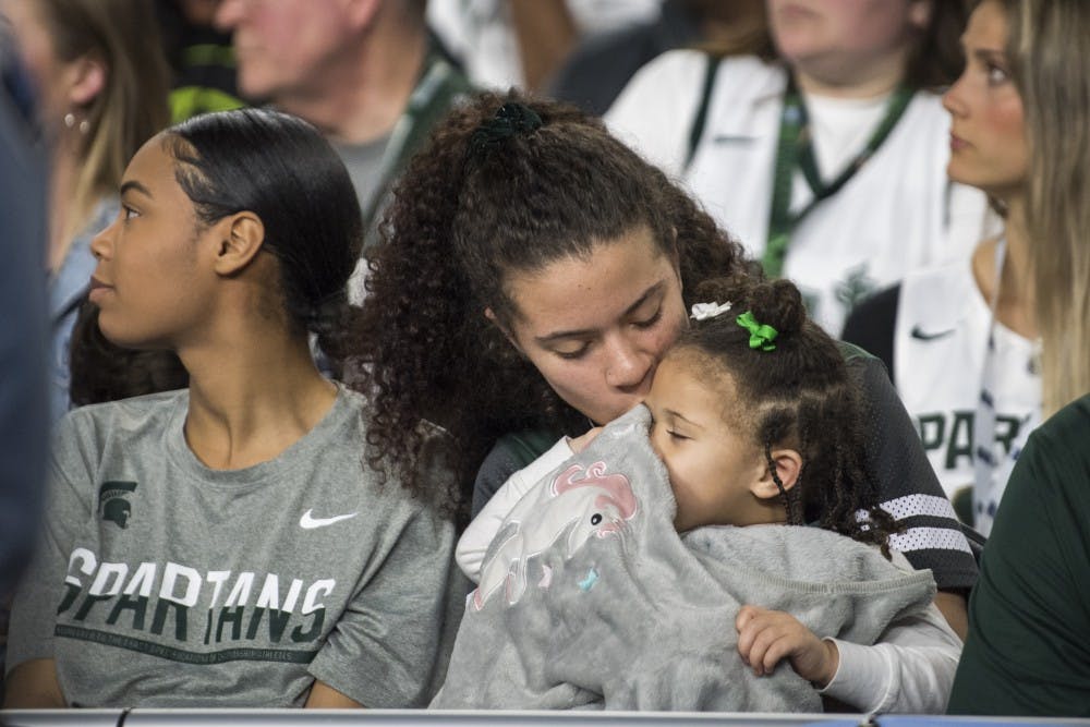 Tamia Todd, fiance of sophomore forward Xavier Tillman (23), kisses her daughter, Ayanna Tillman, 2, during the second half of the NCAA Final Four game against Texas Tech at U.S. Bank Stadium in Minneapolis on April 6, 2019. The Spartans lost to the Red Raiders 61-51.  (Nic Antaya/The State News)