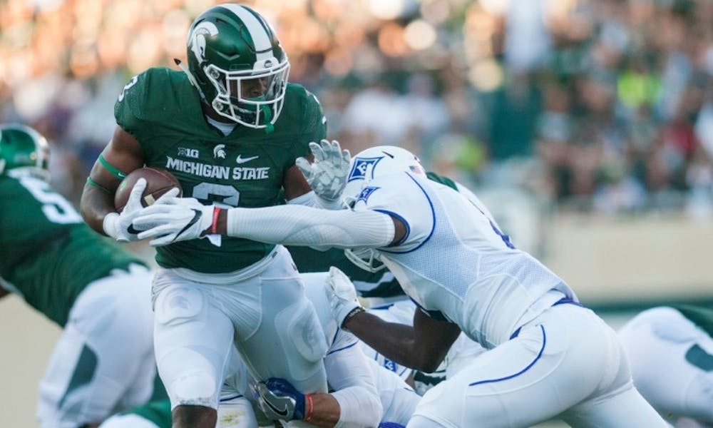 Sophomore running back LJ Scott (3) is tackled by Furman safety Trey Robinson (2) during the home football game against Furman on Sept. 2, 2016 at Spartan Stadium. LJ Scott rushed for a total of 108 yards and scored one touchdown.

