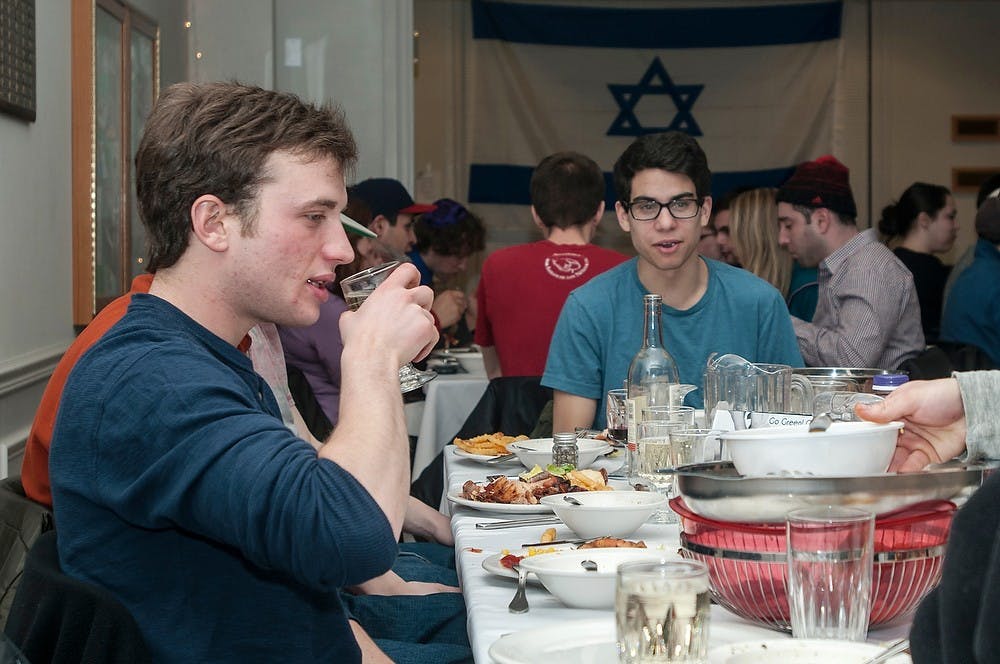 <p>International relations and marketing freshman Leonard Gross, left, and no preference freshman Matt May enjoy a meal after Shabbat services Feb. 21, 2014 at the Hillel Jewish Student Center. The Shabbat is the Jewish day of rest. Casey Hull/The State News</p>