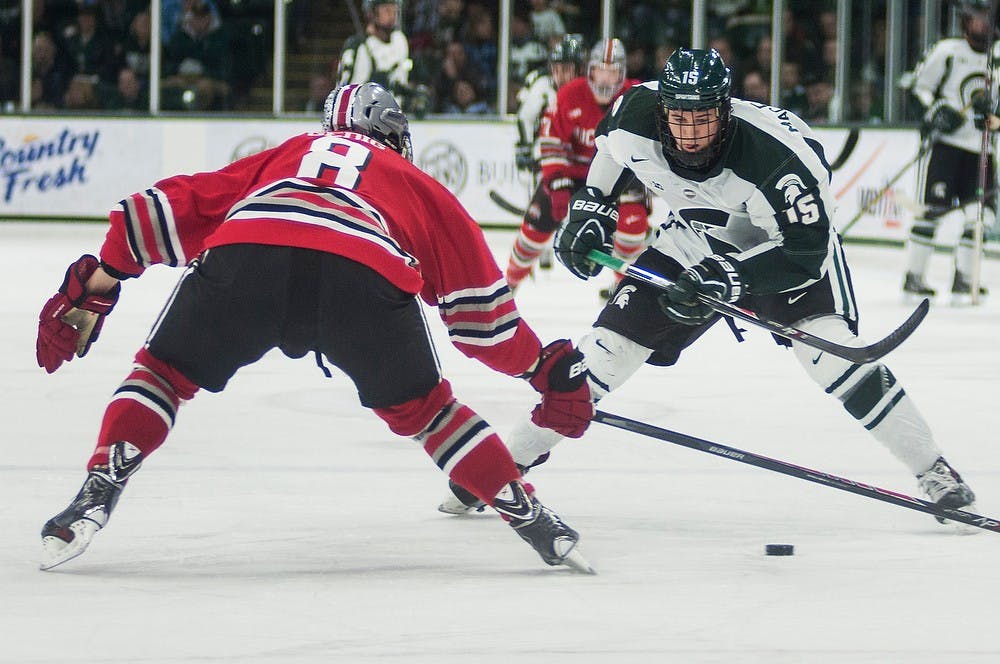 	<p>Freshman forward Mackenzie MacEachern prepares to skate the puck around Ohio State defenseman Curtis Gedig on Feb. 7, 2014, at Munn Ice Arena. The Spartans tied with the Buckeyes, 2-2, and lost the shootout. Danyelle Morrow/The State News</p>