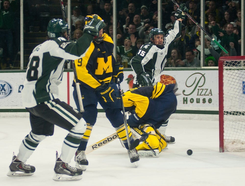 <p>Freshman forward Mackenzie MacEachern scores on Michigan goaltender Steve Racine to put the Spartans in the lead March 8, 2014, at Munn Ice Arena. The Spartans defeated the Wolverines, 4-3. Danyelle Morrow/The State News</p>