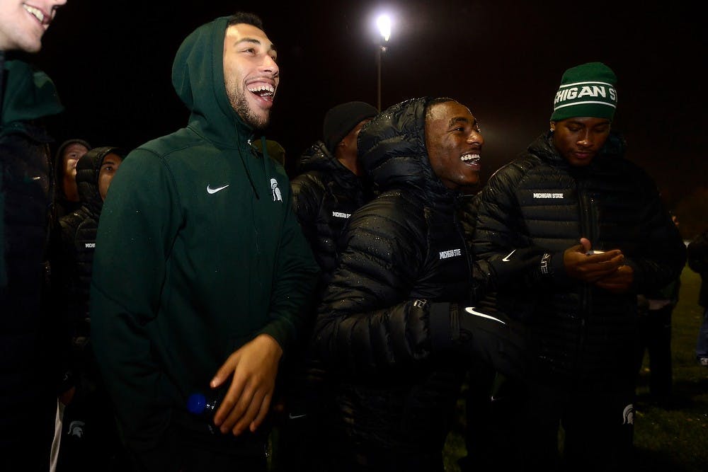 <p>Junior guard Denzel Valentine, left, and freshman guard Lourawls "Tum Tum" Nairn Jr. laugh Oct. 17, 2014, during the Izzone Campout at Munn Field. Hundreds of students battled the cold and rain to sleep outdoors overnight in hopes of getting lower bowl seating. Julia Nagy/The State News</p>