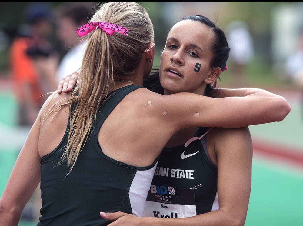 <p>Teammates Senior Leah O'Connor (left) and Senior Sara Kroll embrace one another after competing in the women's 1,500 meter preliminary race at the Big Ten Conference Championships May 16, 2015 at Ralph Young Field. Wyatt Giangrande/ State News</p>