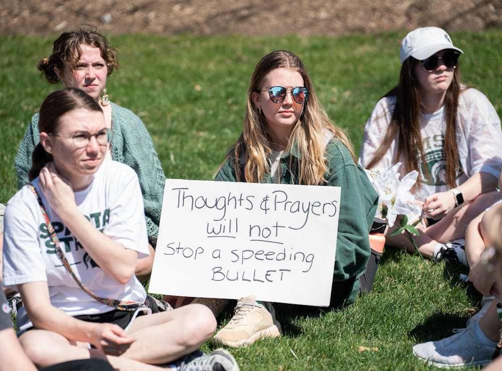 <p>An MSU student holds a sign saying, 'Thoughts &amp; Prayers will not stop a speeding bullet' after a walkout protest against gun violence from Berkey Hall to the Spartan Statue on April 12, 2023.</p>