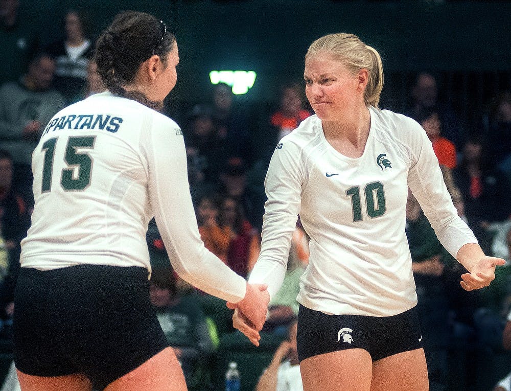 	<p>Junior middle blocker Kelsey Kuipers (10) reassures junior outside hitter Lauren Wicinski (15) before the start of a game against Illinois on Saturday Oct. 13, 2012 at Jenison Field House. Katie Stiefel/ State News</p>
