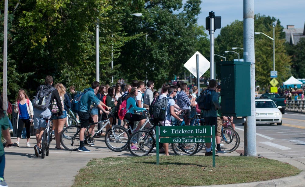 <p>Cyclists and pedestrians wait Sept. 10, 2015 on Farm Lane between classes. Jack Stephan/ The State News</p>