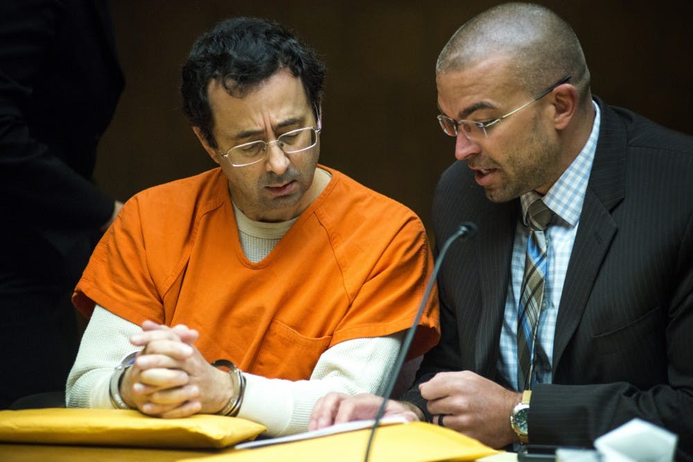Former MSU employee Larry Nassar, left, converses with his defense attorney, Matt Newburg, during a preliminary examination conference on March 2, 2017 at 55th District Court in Mason, Mich. Nassar's preliminary examination was deferred to May 12, 2017.