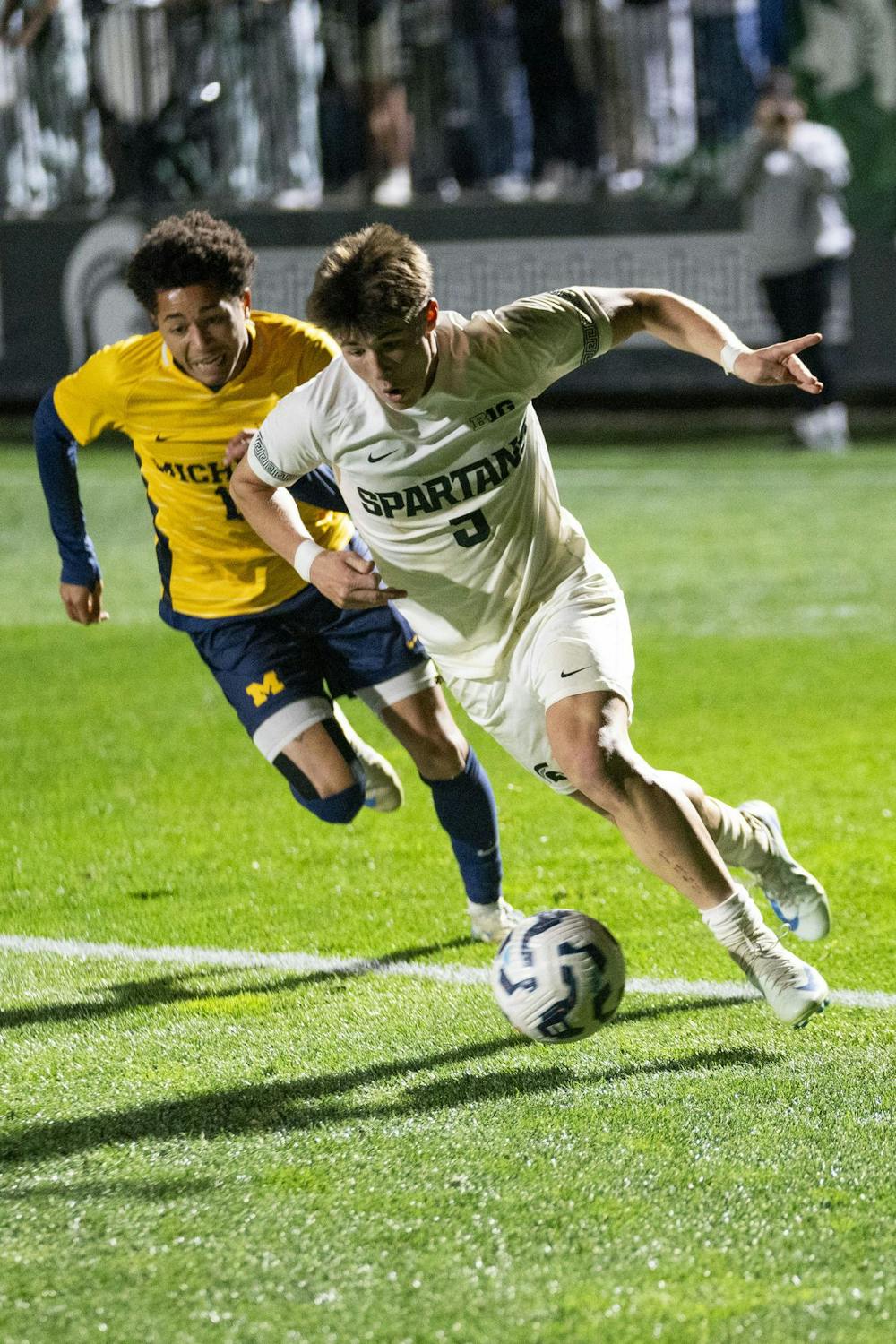 Michigan State University freshman defender Brandon Munson (5) and University of Michigan junior forward Oliver Martin (15) run after the ball during the MSU vs. UofM men’s soccer game at the DeMartin Soccer complex on Oct. 22, 2024. 