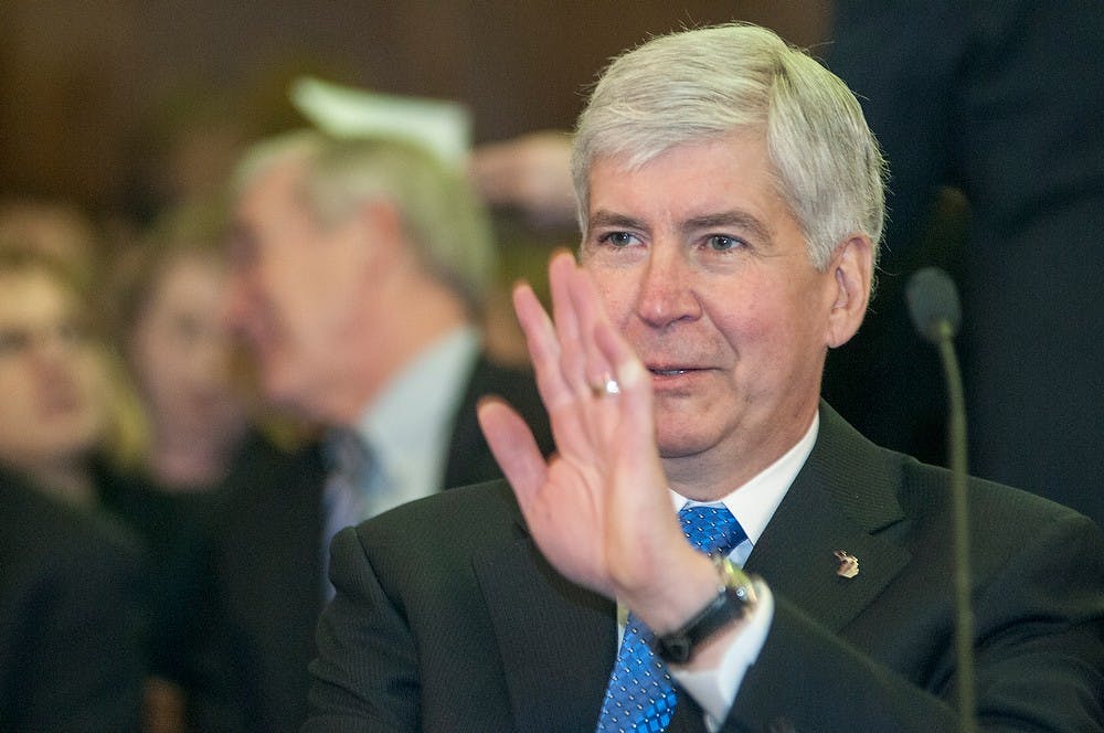 <p>Gov. Rick Snyder waves to a representative before presenting the 2015-2016 state budget Feb. 11, 2015, at Boji Tower, 124 West Allegan Street in Lansing. Snyder's budget included increased funding for public community colleges and universities. Kelsey Feldpausch/The State News</p>