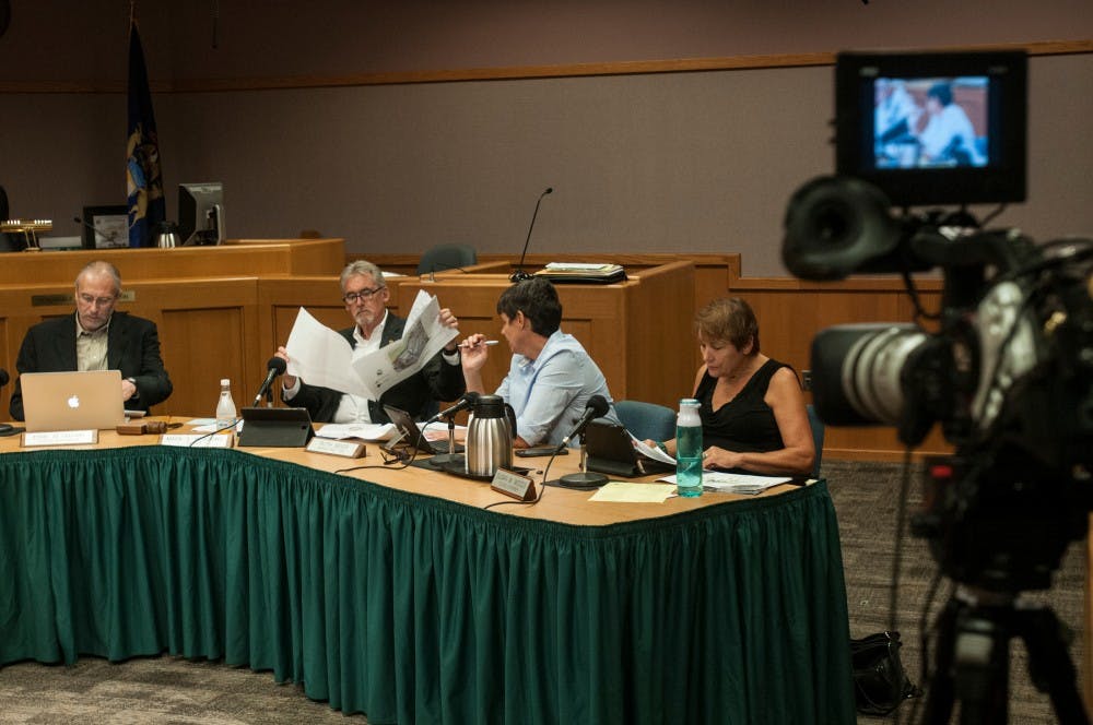 East Lansing City council members including Mayor Mark Meadows, center, review construction plans of a gas station during a city council meeting on Sept. 13, 2016 at East Lansing City Hall. The city council meets to take action on legislative matters on several Tuesdays of each month.