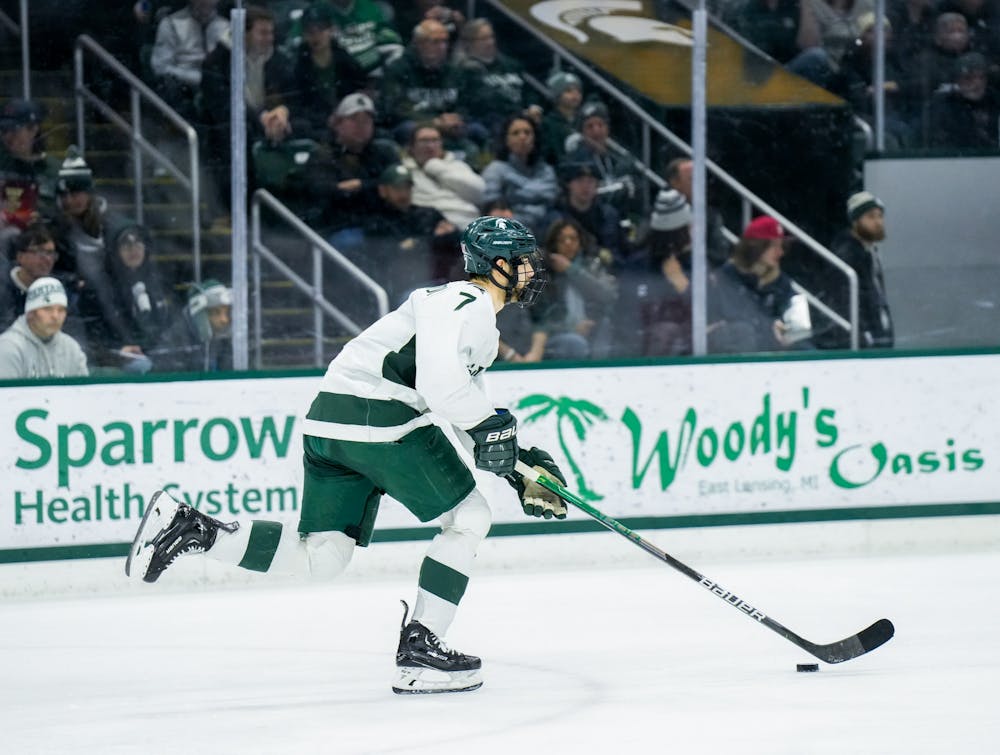 <p>Sophomore defender David Gucciardi (7) dribbles the puck during a game against Notre Dame at Munn Ice Arena on Feb. 3, 2023. The Spartans defeated the Fighting Irish 3-0.</p>