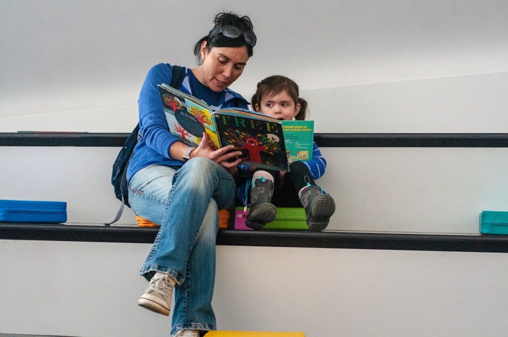 East Lansing resident Crystal Eustice, left, reads to three-year-old East Lansing resident Nora Eustice, right, at the Family Day in the Broad Art Museum on Nov. 3, 2018.