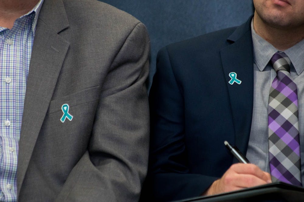 Two members of the presidential search committee wear teal ribbons at the Kellogg Conference Center on Oct. 11, 2018.