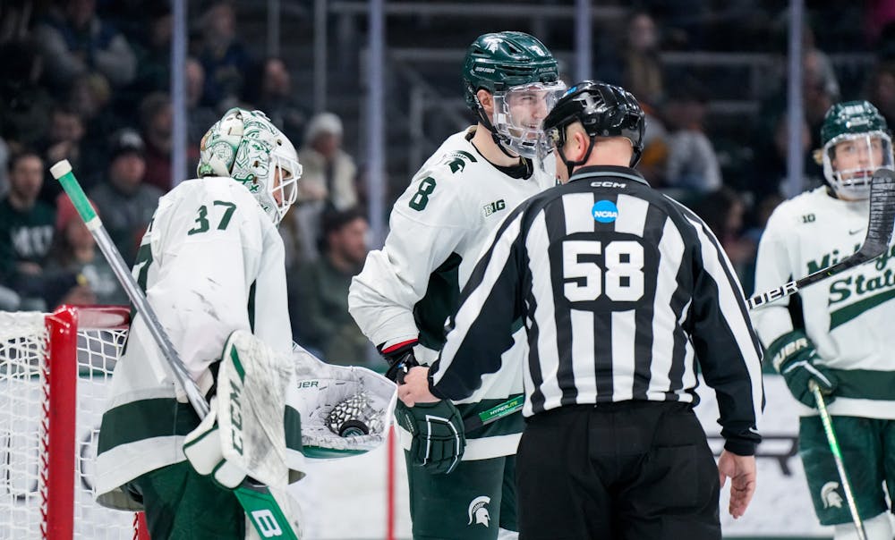 <p>Fifth-year defender Cole Krygier (8) shares a laugh with graduate student goalie Dylan St. Cyr (37) during a game against Notre Dame at Munn Ice Arena on Feb. 3, 2023. The Spartans defeated the Fighting Irish 3-0.</p>