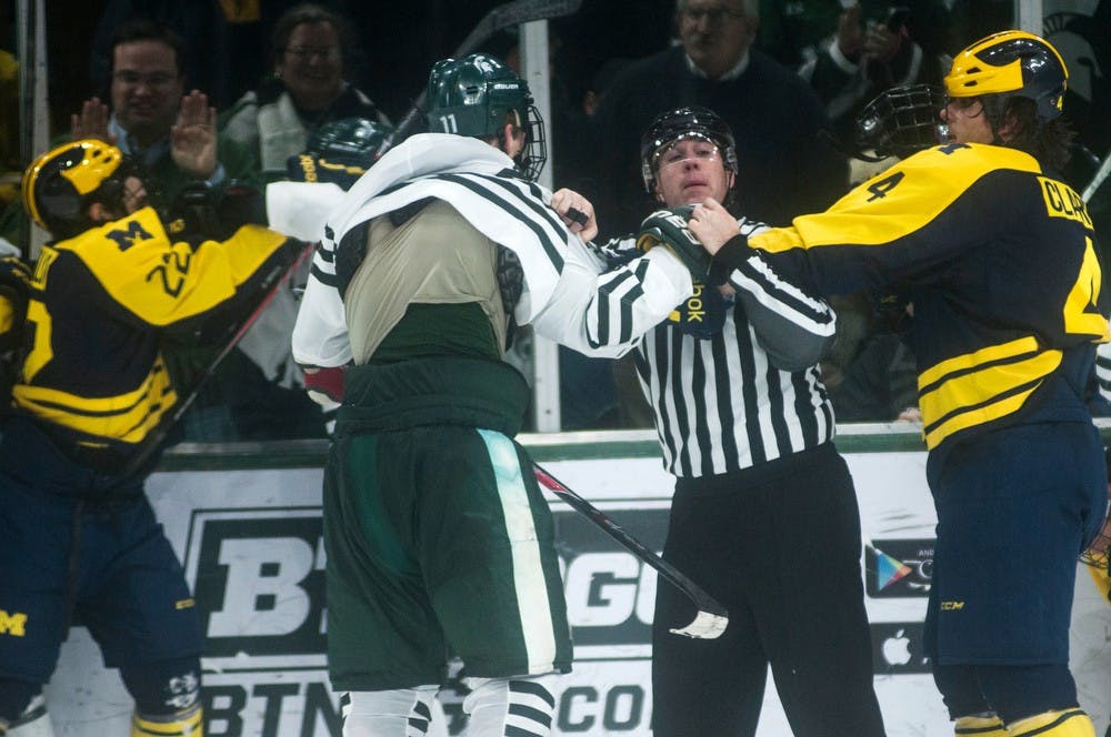 	<p>Redshirt freshman defenseman Rhett Holland and Michigan defenseman Kevin Clare get into a fight Jan. 24, 2014, at Munn Ice Arena. Their fight was one of a few other fights between the teams. The Wolverines defeated the Spartans, 5-2. Erin Hampton/The State News</p>