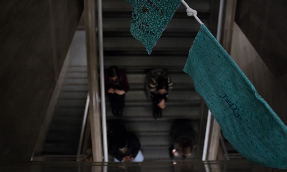 Attendees of the Sister Survivors Speak series watch from the steps of the MSU Museum on Jan. 15, 2019. Above them hang Tibetan prayer flags made in support of sexual assault and abuse survivors.