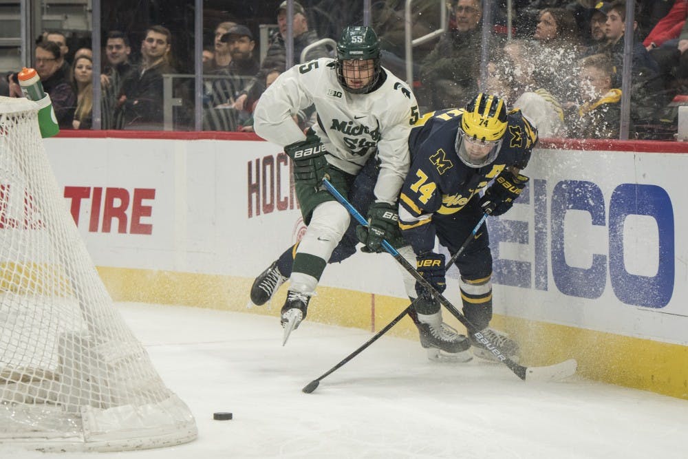 Junior center Patrick Khodorenko (55) and Michigan defenseman Nicholas Boka (74) collide during the Duel in the D at Little Caesars Arena in Detroit on Feb. 9, 2019. Michigan defeated Michigan State 5-2. Nic Antaya/The State News