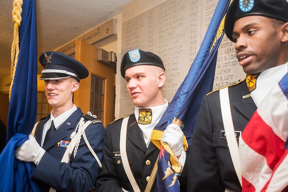 <p>From right, psychology senior Sheldon Holmes, political science junior Weston McJames, and packaging junior Daniel Thomas hold flags outside of the chapel Nov. 11, 2014, after the Veteran's Day Chapel Service at The Alumni Chapel, 600 Auditorium Rd. in East Lansing. </p>