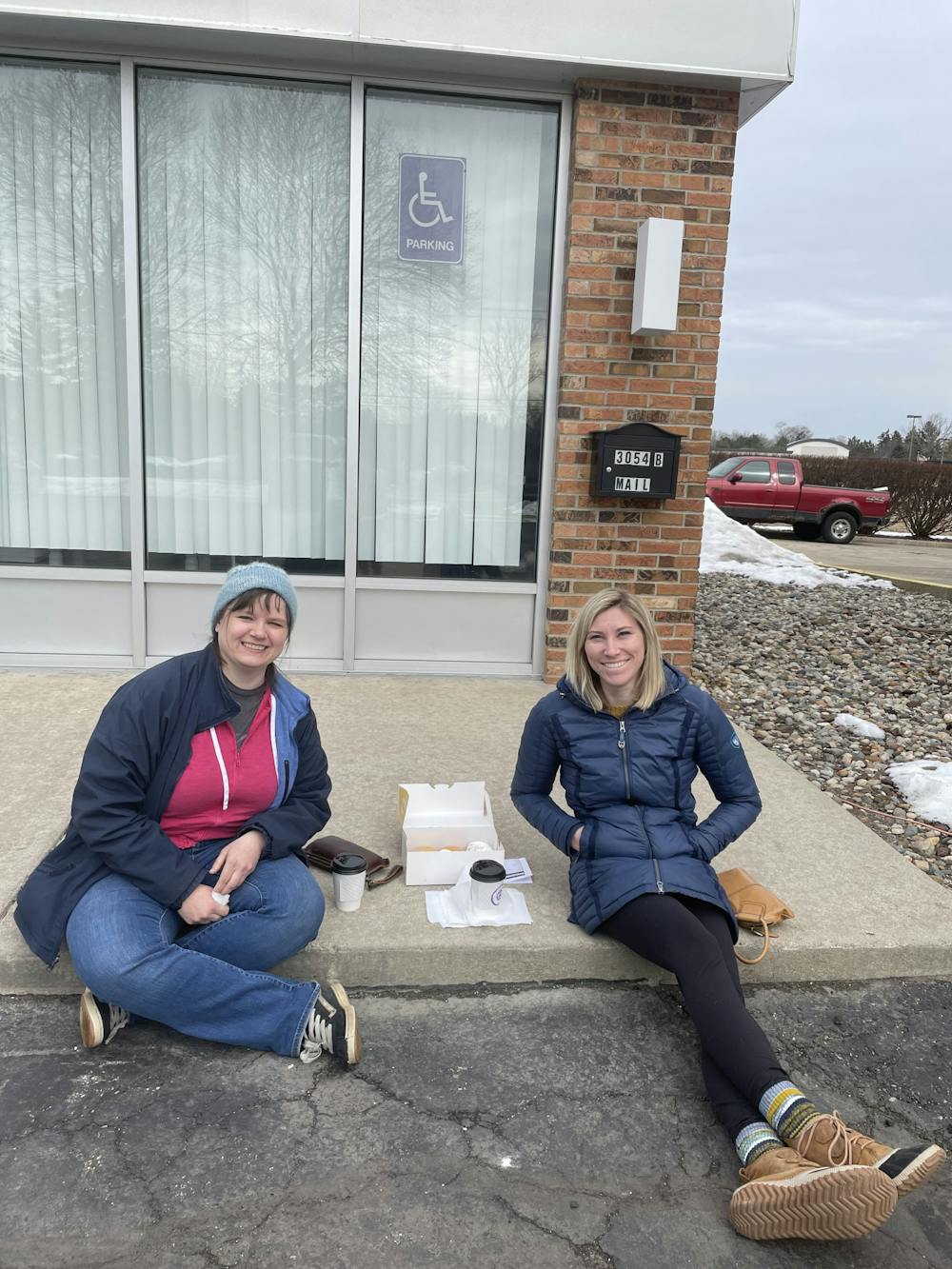 <p>Coworkers Lisa Eldred and Nicole Morris sit outside of Groovy Donuts in Lansing, Michigan, to carry on their tradition of getting paczki together on Fat Tuesday. The two have been celebrating the day for nine years. </p>