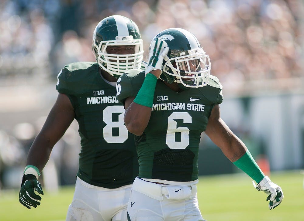 <p>Senior linebacker Mylan Hicks, 6, celebrates his sacking Wyoming quarterback Colby Kirkegaard on Sept. 27, 2014, at Spartan Stadium. The Spartans defeated the Cowboys, 56-14. Raymond Williams/The State News</p>