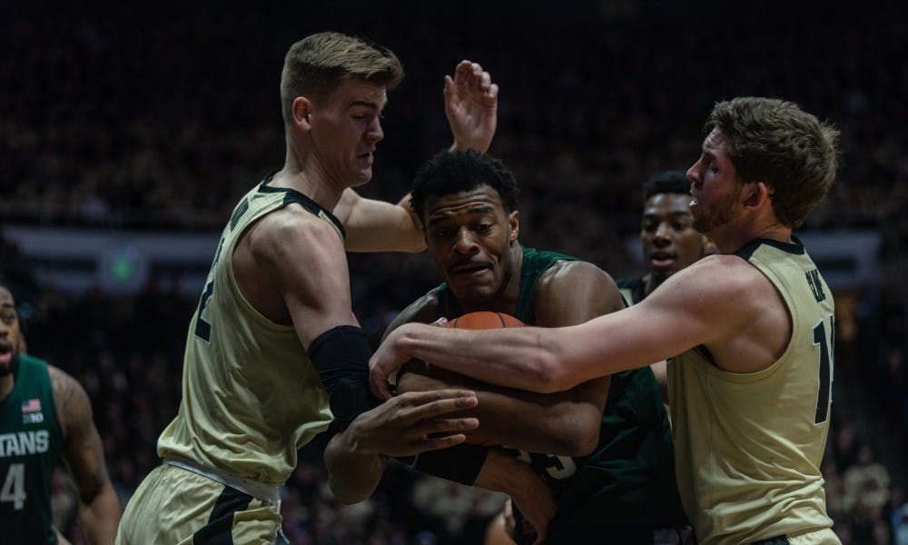 <p>Sophomore forward Xavier Tillman (23) wrestles a loose ball away from Purdue's Matt Haarms and Ryan Cline at Mackey Arena on Jan. 27, 2019. The Spartans fell to the Boilermakers, 73-63.</p>