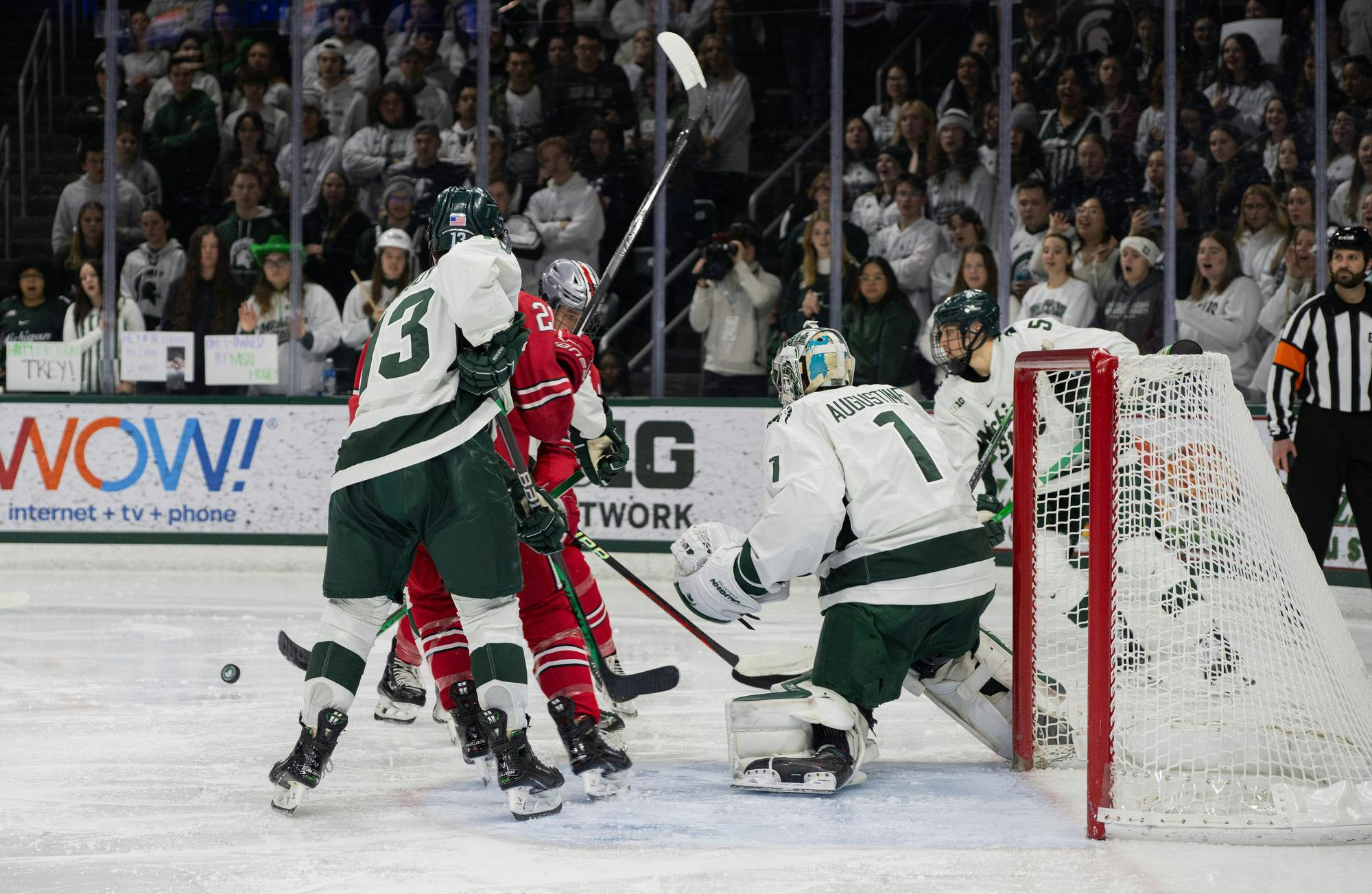 Ohio State Senior forward Joe Dunlap #21 tries to score against the Spartans while MSU Sophomore forward Tiernan Shoudy #13 defends at Munn Ice Arena on Feb. 23, 2024.