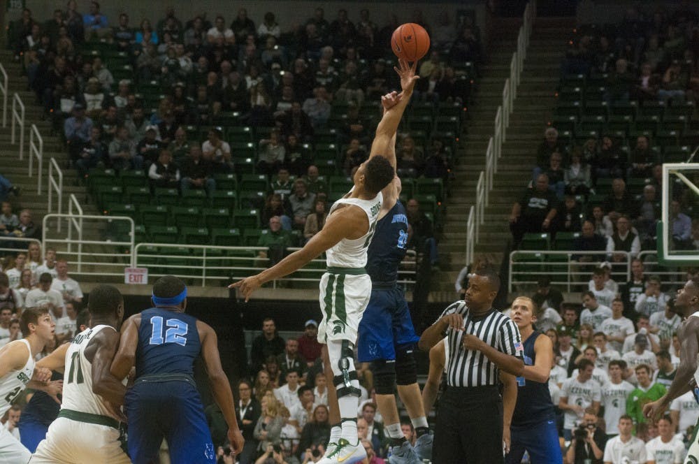 Sophomore forward Kenny Goins up for the ball on the opening tipoff during the first half of the basketball game against Northwood on Oct. 27, 2016 at Breslin Center. 