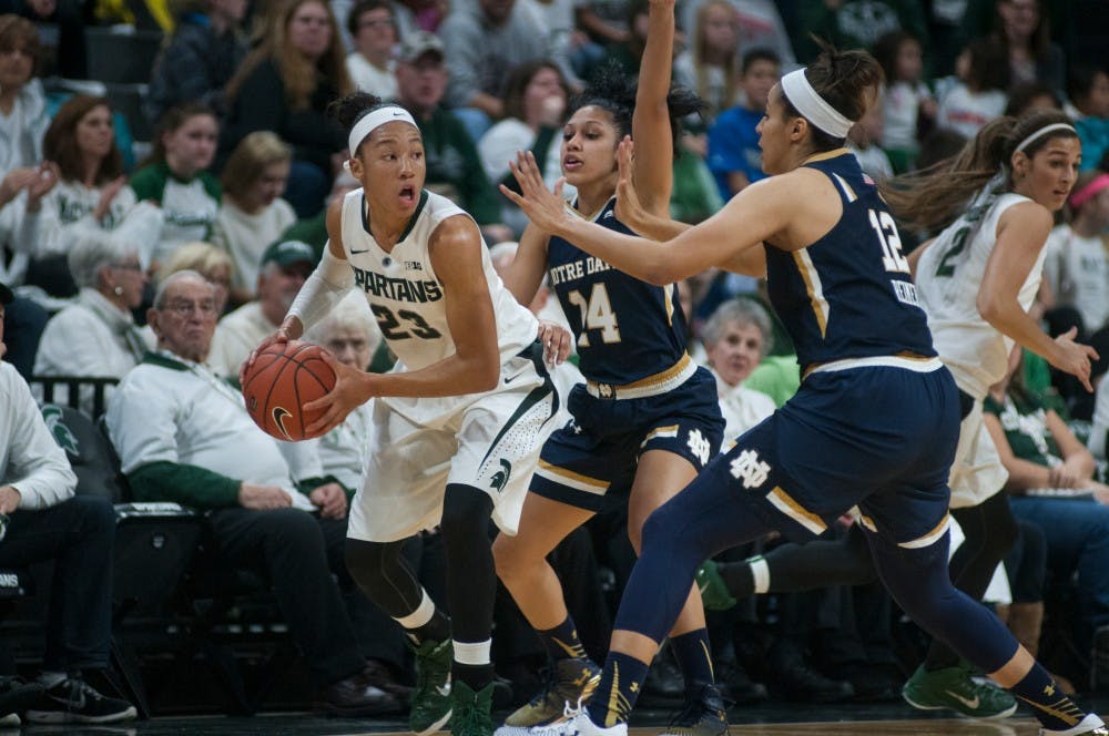 <p>Redshirted sophomore forward Aerial Powers controls the ball as Notre Dame guard Mychal Johnson, 14, and forward Taya Reimer, 12, defends her during the game on Nov. 19, 2014, at the Breslin Center. The Spartans lead the Fighting Irish at halftime, 30-29. Aerika Williams/The State News.</p>