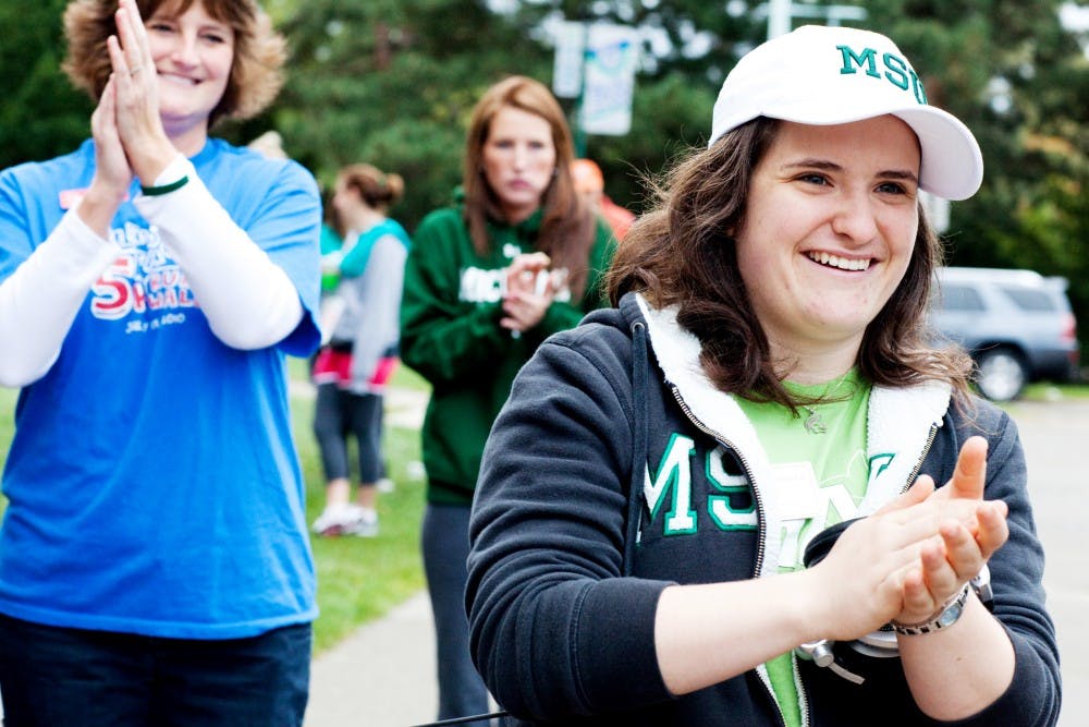 RHA president and Homecoming Court member Sarah Pomeroy claps as runners take off for the Spartan 5k. Pomeroy is one of ten students who made it through the interview process to become a part of the court. Matt Hallowell/The State News