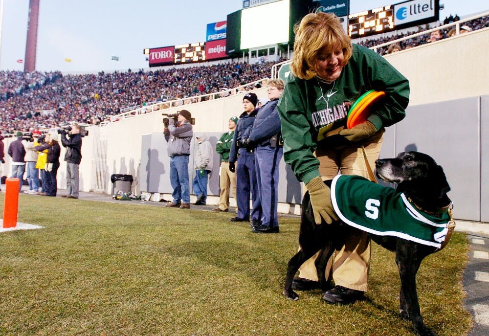 Zeke the Wonder Dog is a tradition that started in 1977 when Gary Eisenberg, an alumnus, was invited to a home football game to perform with his dog. In the early 1980s, the MSU Department of Intercollegiate Athletics began to look for a Zeke look-a-like after the death of two replacements. Zeke, whose real name is Dexter, began his training when he was approximately one year old when the Foleys adopted him from the Humane Society. In the warmer months, Zeke practices two to three times a week. ?He was very focused on the Frisbee,? said owner Terri Foley, far right with Zeke, a Holland resident and Blue Cross Blue Shield case manager. Jeana-Dee Allen/The State News