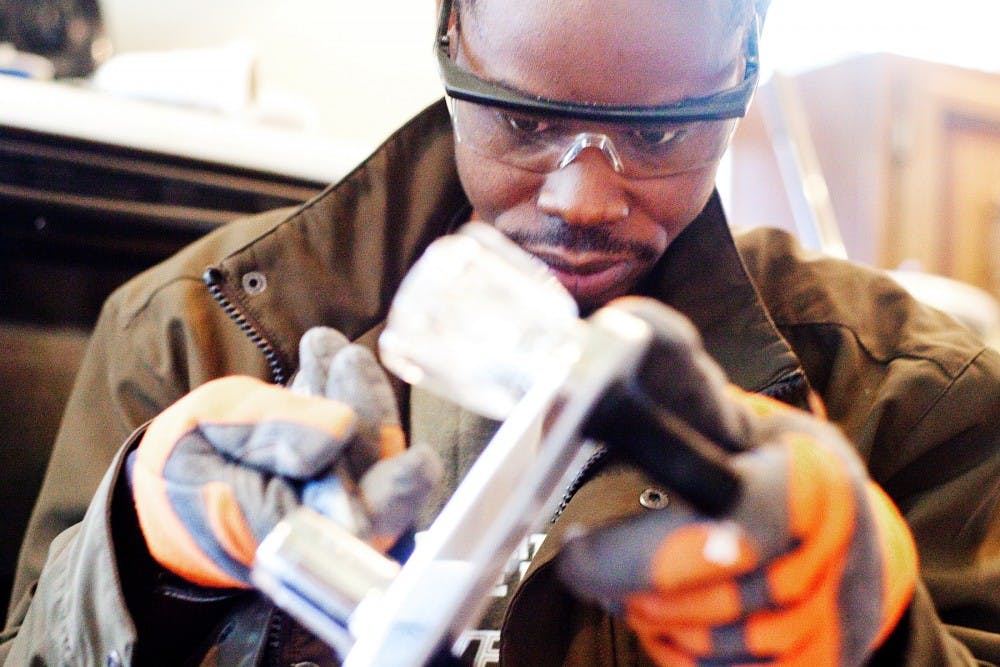 	<p>Khalika Kaba fastens knobs on his soon-to-be kitchen sink Tuesday afternoon in his Lansing home. Kaba came to Lansing in 2008 as a refugee after fleeing from a conflict-filled Congo. </p>