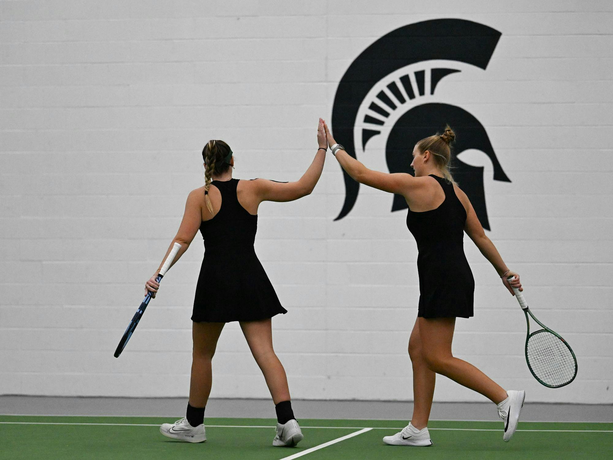 Issey Purser, a senior, and Nina Pihal, a sophomore, celebrate a point during a doubles match at the MSU Tennis Center on Friday, Feb. 6, 2026, in East Lansing,