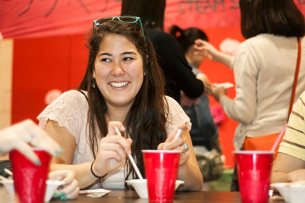 <p>Elementary education sophomore Wendy Potter laughs while talking with friends during the Island Bazaar hosted by the MSU Japan Club and Taiwanese Student Association on April 12, 2014, at First Christian Church, 1001 Chester Road in Lansing. The event hosted games, performances, and traditional food for attendees. Danyelle Morrow/The State News</p>