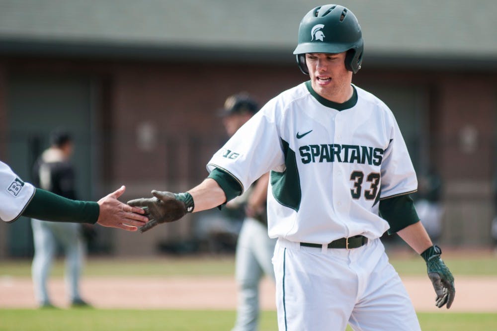 A spartan low-fives junior outfielder Brandon Hughes (33) during the game against Western Michigan University on March 28, 2017 at McLane Stadium at Kobs Field. The Spartans were defeated by the Broncos, 3-2. 