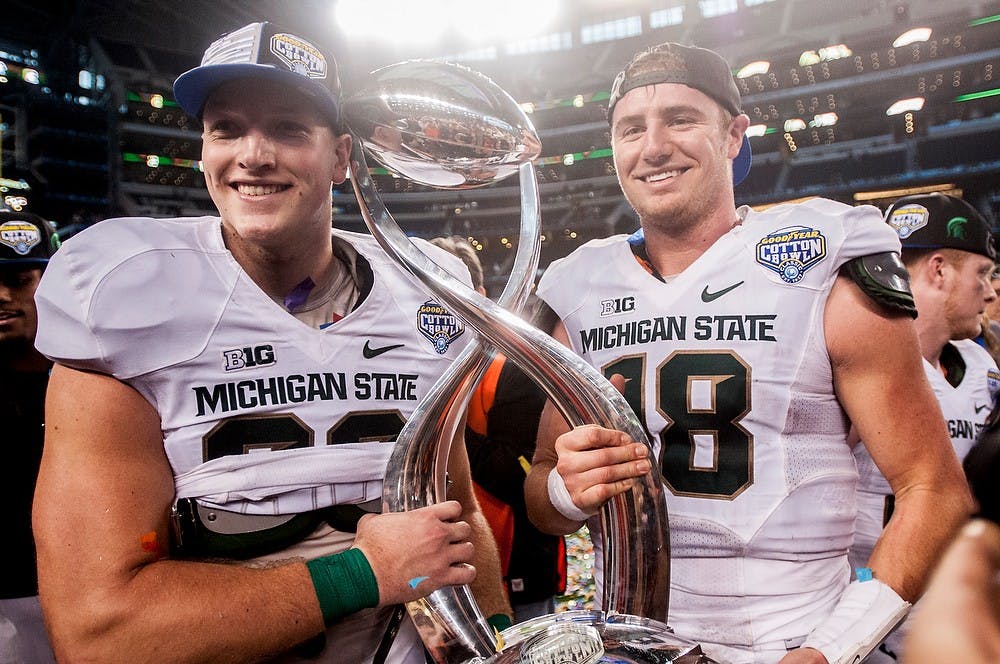 <p>Sophomore tight end Josiah Price and junior quarterback Connor Cook hold the trophy Jan. 1, 2015, after The Cotton Bowl Classic football game against Baylor at AT&T Stadium in Arlington, Texas. The Spartans defeated the Bears and claimed the Cotton Bowl Victory, 42-41. Erin Hampton/The State News</p>