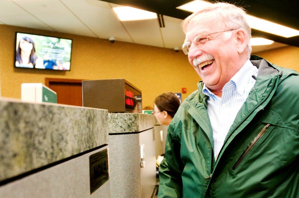 Holt resident Dick Sigelko finishes a transaction at the newest Michigan State University Federal Credit Union, 4825 E. Mt. Hope Road. The credit union opened on March 5, 2012. Jaclyn McNeal/The State News