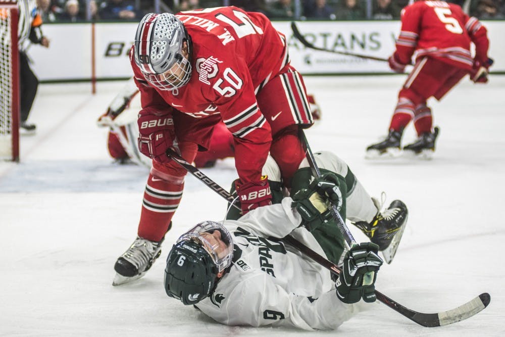 Freshman right wing Mitchell Lewandowski (9) collides with Ohio State's Matt Miller (50) during the men's hockey game against Ohio State on Jan. 5, 2018 at the Munn Ice Arena. The Spartans were defeated by the Buckeyes, 4-1. (Nic Antaya | The State News)