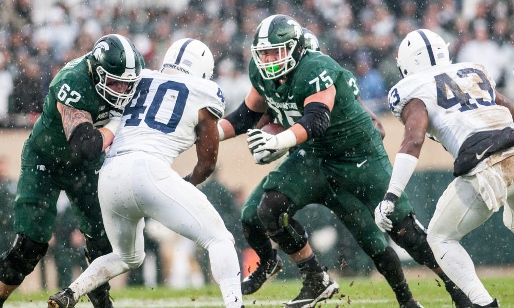 <p>Freshman offensive guard Kevin Jarvis (75) and redshirt freshman offensive tackle Luke Campbell (62) block for a run play during the game against Penn State, on Nov. 4, 2017, at Spartan Stadium. The Spartans defeated the Nittany Lions, 27-24.</p>