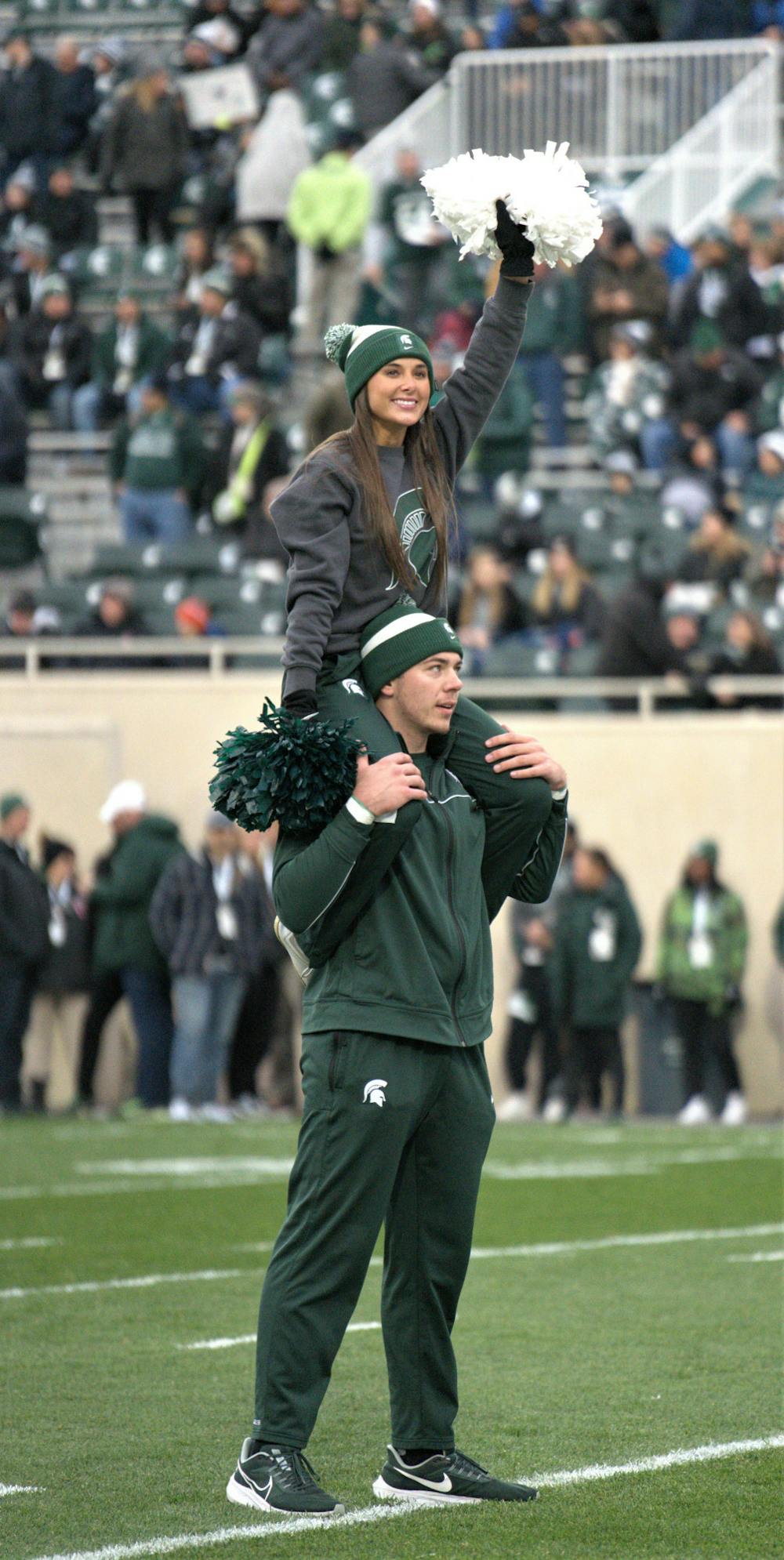 <p>Spartan cheerleaders wave to the crowd during the game against Rutgers on Nov. 12, 2022. ﻿</p>
