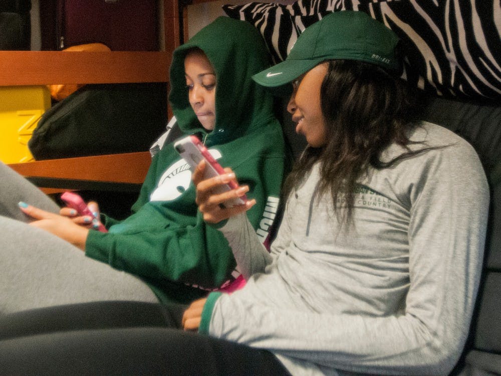 Communications sophomore Asya Reynolds, right,  sits on a couch with her friend Debbie Threatt who is visiting from out of town on Sept. 30, 2016 at South Wonders Hall.  Reynolds is a track athlete for MSU.  