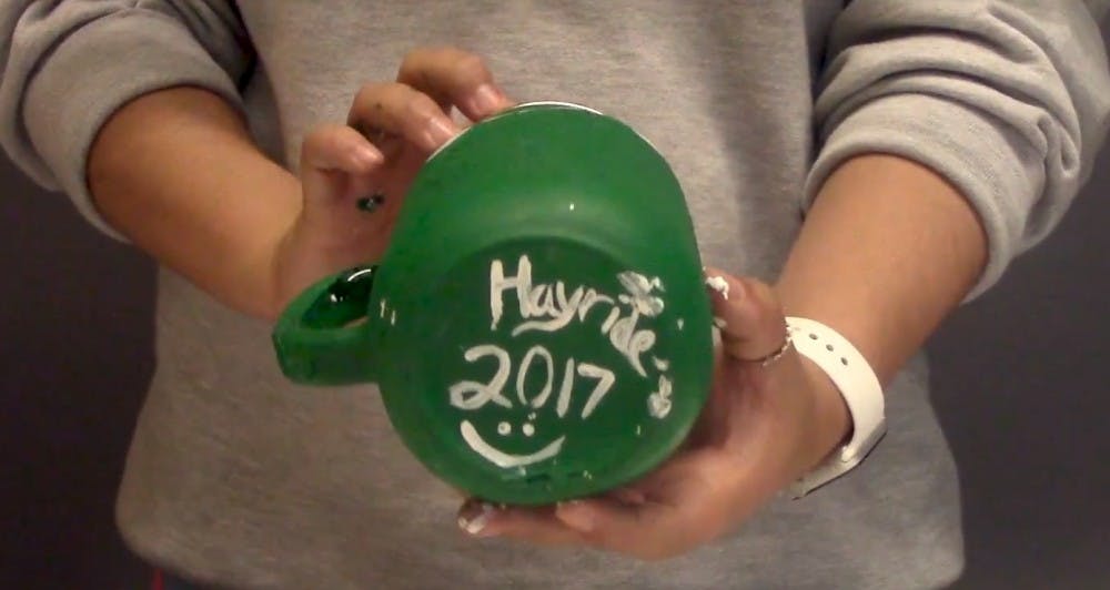 A jug used for hayrides is painted during a State News how-to video.