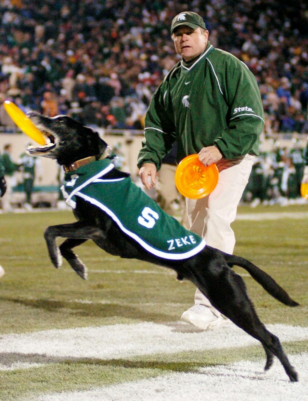 Zeke entertains the crowd on Saturday evening during halftime of the game against Penn State at Spartan Stadium. Owner Jim Foley, a Holland resident, prompts Zeke to perform numerous flying disc tricks. Foley later gives away some of the discs, which are ?autographed? with a stamp of Zeke?s paw print. ?[Zeke] thoroughly enjoys himself. When he?s out there, he gives 110 percent. He?s just a dog; he doesn?t know anything about winning or loosing. He just goes out there and has fun.? Jeana-Dee Allen/The State News