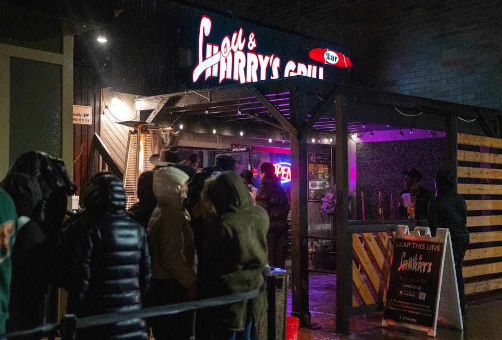 <p>MSU students wait outside in the rain to get into Lou &amp; Harry's Bar and Grill on Jan. 19, 2023. </p>