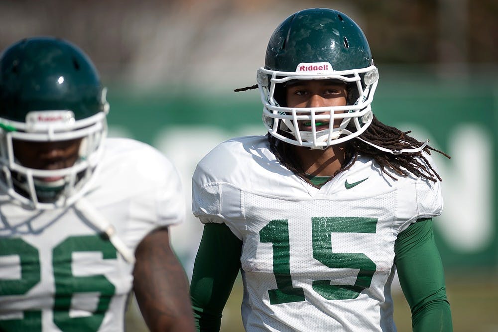 <p>Junior cornerback Trae Waynes walks during football practice April 8, 2014, at the practice field outside Duffy Daugherty Football Building. Julia Nagy/The State News</p>