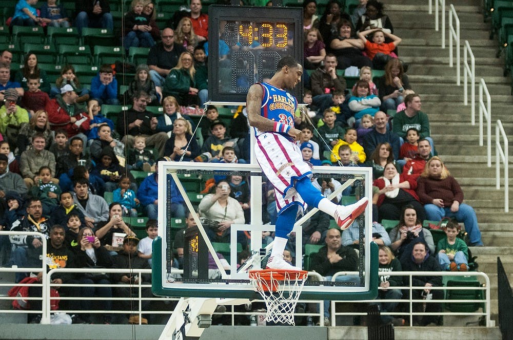 	<p>Harlem Globetrotters guard Bull stands on top of the basket to halt play Jan. 24, 2014, at Breslin Center. The team engaged the audience with comedy and interactive play throughout the evening. Danyelle Morrow/The State News</p>